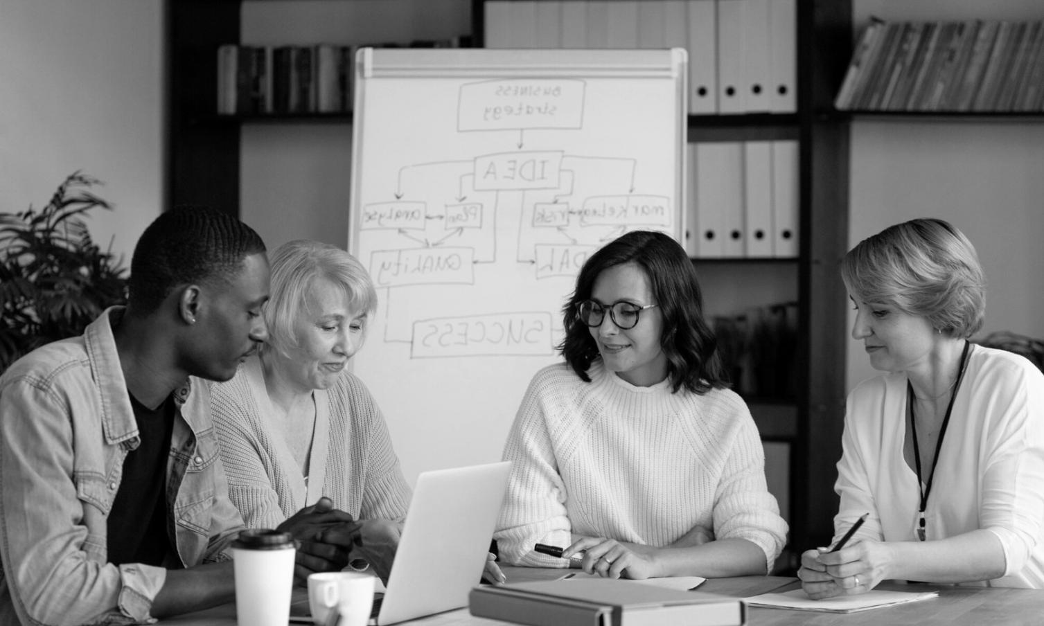 Business meeting discussing budget prioritization strategies with charts and financial documents